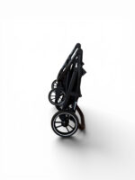 Folded black baby stroller standing upright on a white background, showcasing its wheels and frame.
