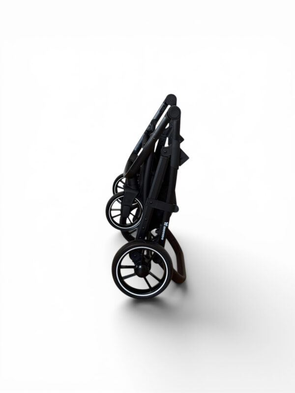 Folded black baby stroller standing upright on a white background, showcasing its wheels and frame.