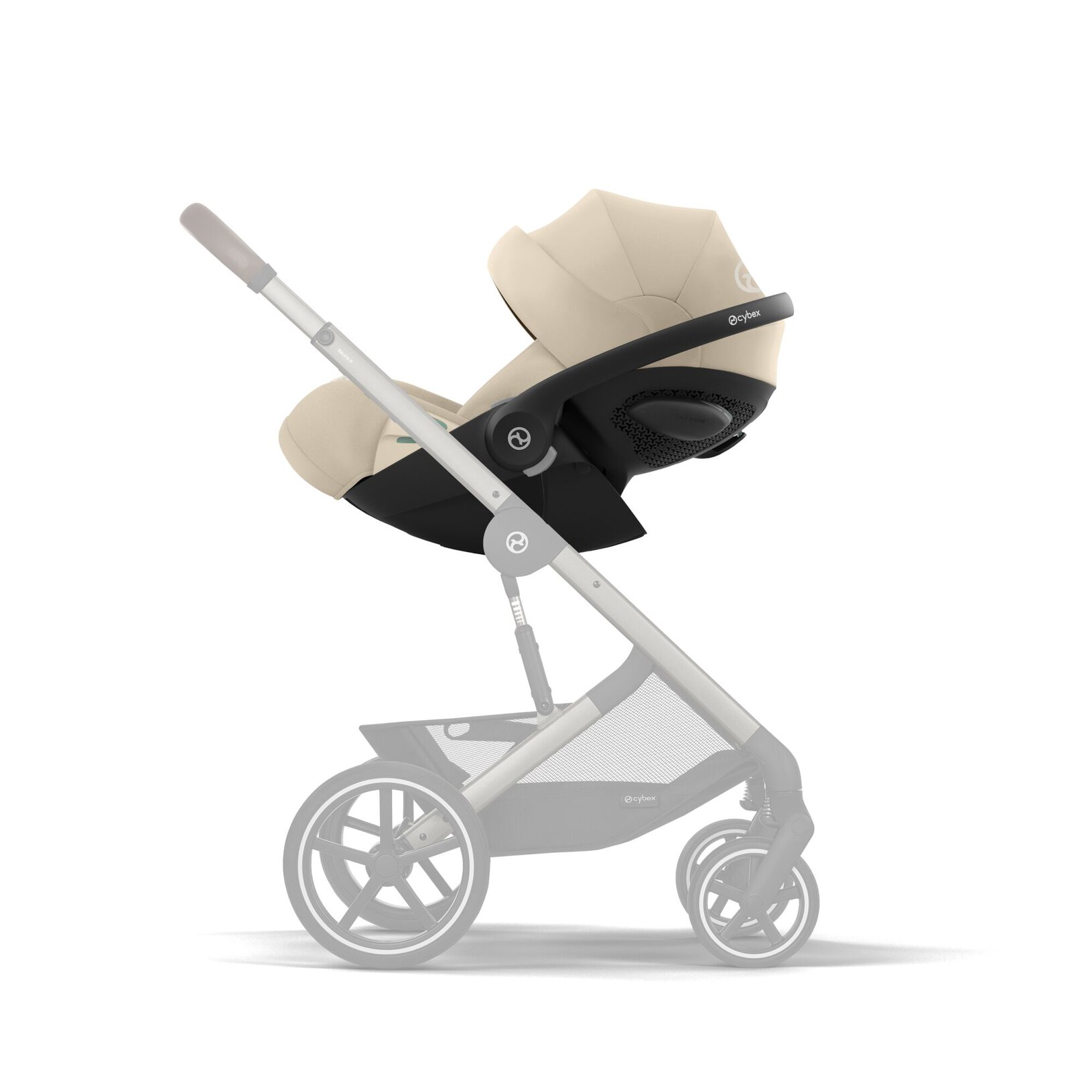 Beige-brown baby stroller with a black frame and large wheels shown from the side, bassinet attached to chassis.