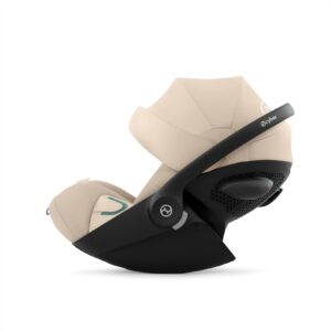Beige infant stroller seat with a black frame, isolated on a white background.