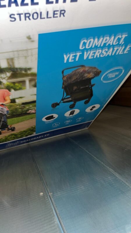 Blue advertising panel showing a compact, versatile stroller with a patterned canopy and the text 'COMPACT, YET VERSATILE' in bold white letters.