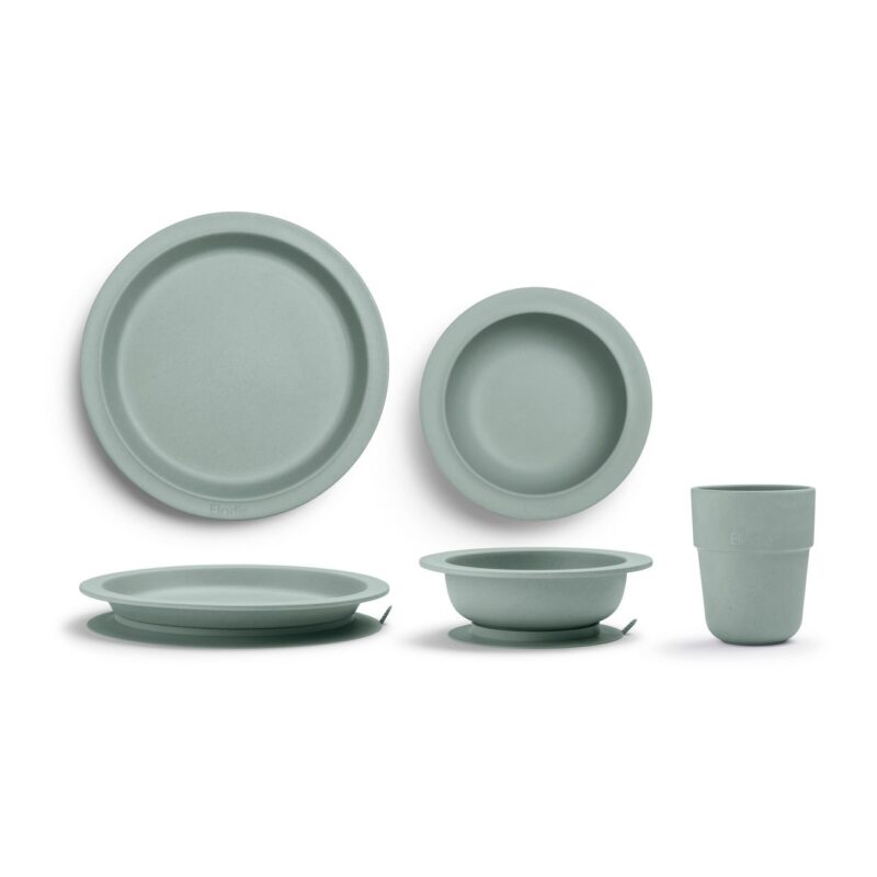 Sage green silicone dinnerware set: two plates, two bowls, and a cup arranged for product photography.