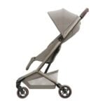 Beige baby stroller with a large canopy and three wheels, shown from the side.