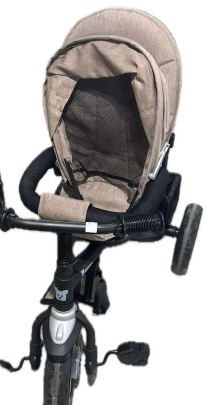 Beige child bicycle seat attached to a black bike frame, with a mesh canopy and footrests visible.