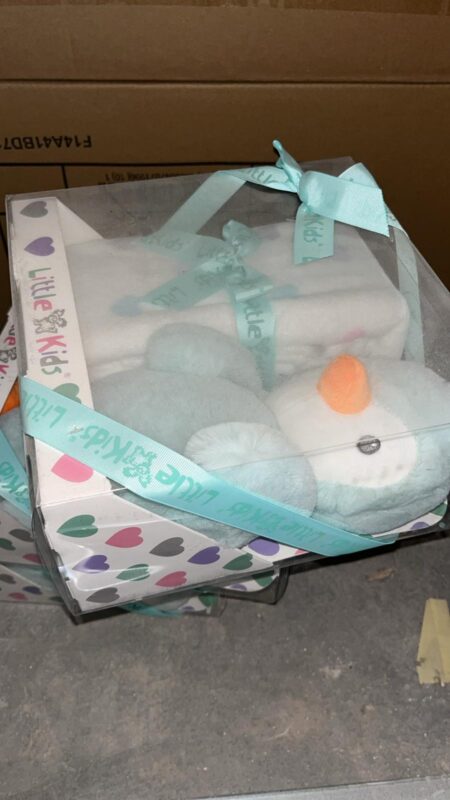 Gift box containing a pastel blue plush bunny, wrapped with a turquoise ribbon and a heart-pattern base.