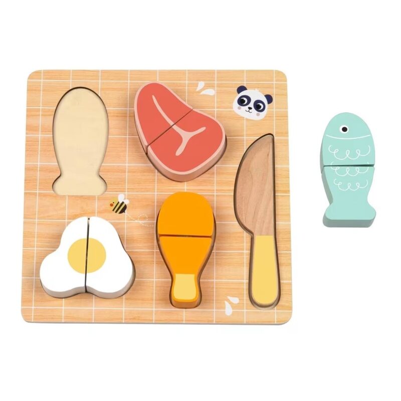 Drvena-Igraka---Izrei-Hranu-318940-Slika-1-20260512132701742857 Wooden pretend-food cutting set on a grooved board with separable pieces and a plastic knife; includes egg, steak, carrot, and a teal storage piece nearby.