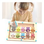 Young child playing with a wooden counting abacus with colorful beads, using a blue stylus tool on a tabletop.