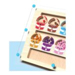 Colorful toy color buckets with smiling faces and numbered labels on a wooden tray (educational counting game).