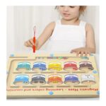 Young girl playing with a bead-counting educational game, using a red wand to move tiny beads along numbered color jars in a wooden board.