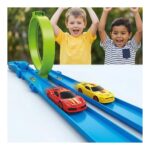 Two kids celebrate as red and yellow toy race cars speed along a bright blue track with a green loop.