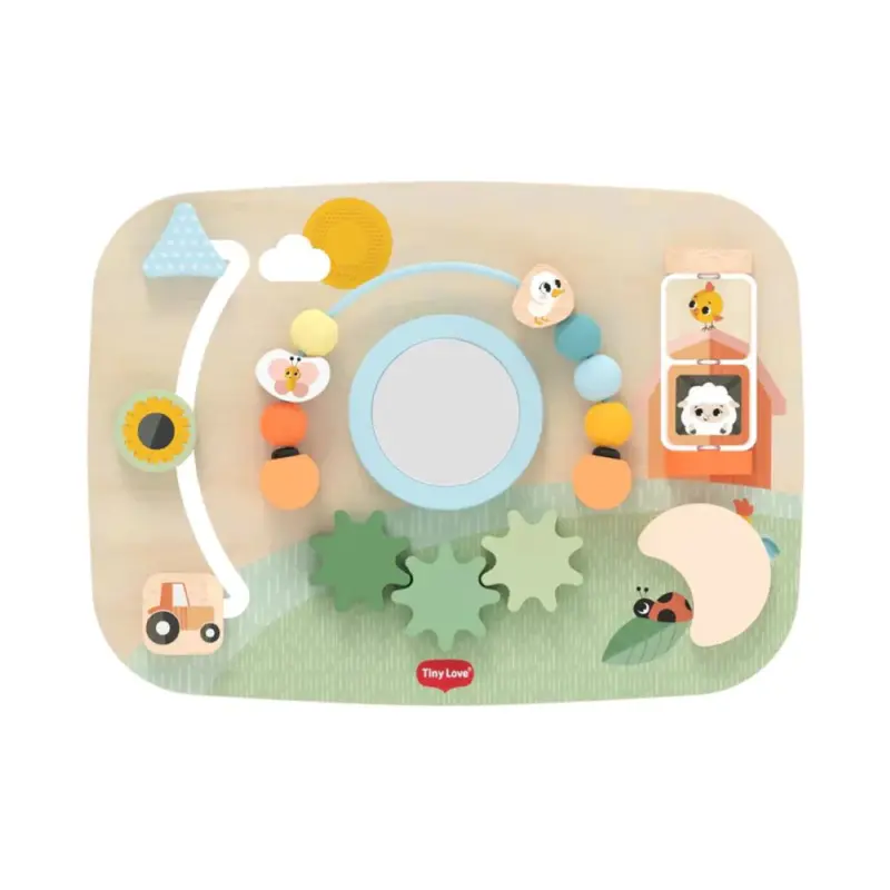 TinyLove_WoodenBusyBoard_FarmersFundayMainImage Colorful wooden baby activity board with beads on a string, a mirror in the center, and playful shapes and animals across a grassy landscape.