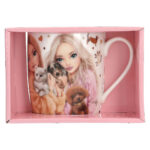 Pink mug featuring a illustrated girl with puppies, packaged in a pink box.