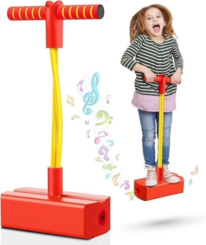 Child stands on a red pogo-stick toy with a yellow spring and T-bar handle, cheerful and ready to bounce.