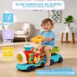 Sretno dijete vozi šareni plastični vlak s volanom u dnevnoj sobi; edukativna igračka za djecu 1–5 godina.