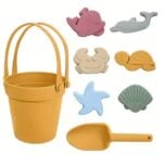 Yellow plastic sand bucket with matching orange shovel and assorted sea-life sand molds (crabs, whale, turtle, starfish, shell).