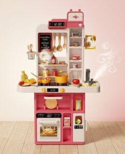Colorful pink and white toy kitchen set with stove, oven, fridge, and shelves for pretend play includes pots, pans, utensils and food items on display.