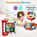 Baby plays with a colorful music toy and its box, featuring 'Glazbeni Instrument' packaging and a volume control illustration.