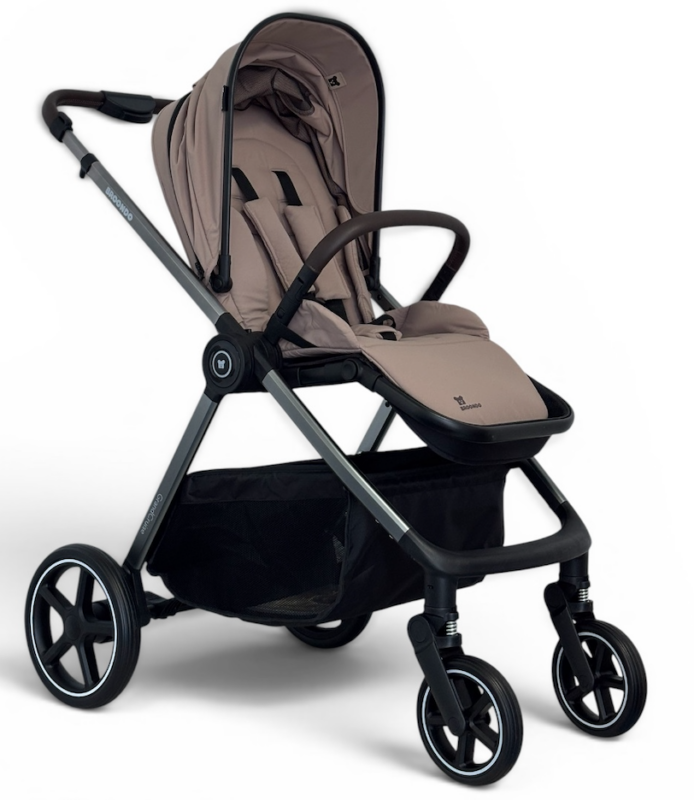 Beige baby stroller with black frame, canopy, and large undercarriage basket.|Beige seating, retractable canopy, and four wheels on a stoller with a sturdy frame.|Beige infant stroller shown in side profile with storage basket beneath the seat.|Beige stroller featuring a padded seat, safety harness, and front bumper bar.|All-terrain baby stroller with large rear wheels and smaller front wheels.